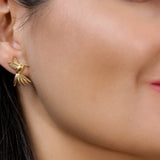 Golden Hummingbird stud earrings in solid gold worn on a model’s ear from the Humming Beauty collection by Aurora Laffite Jewelry.