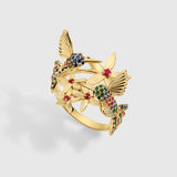 Rainbow Hummingbird ring in solid yellow gold featuring multicolored sapphires and rubies from the Humming Beauty collection by Aurora Laffite Jewelry.